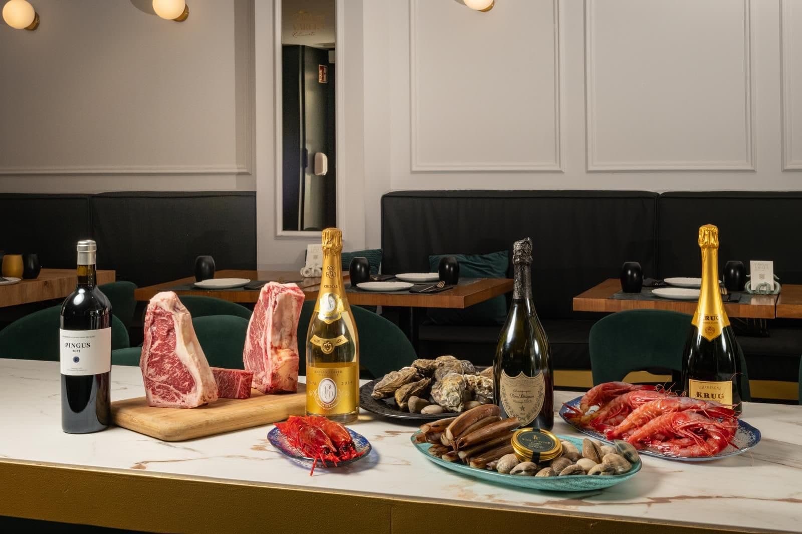 Marisco de lonja, chuletón y vino sobre la mesa de Casa Varela, en L'Hospitalet